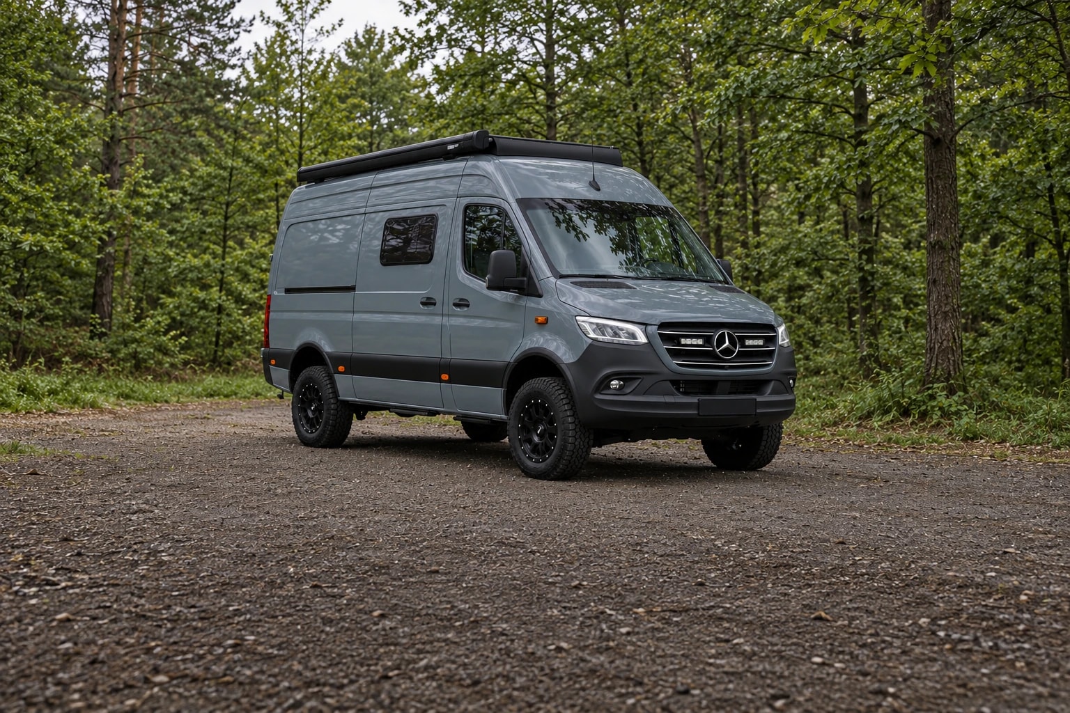 Grauer Bergzeit Sprinter 4x4 Camper an einer Waldlichtung