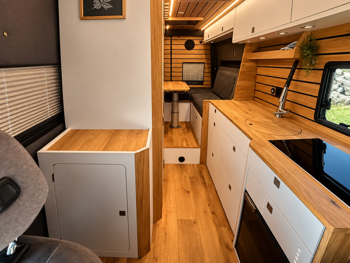 Möbelbank mit Technikfächern und Einstiegsstufe im Busmacher Camper