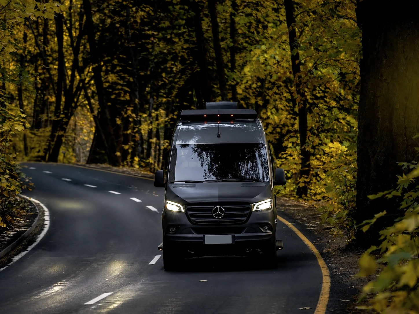 Mercedes-Benz Sprinter Camper auf einer Waldstraße im Herbst