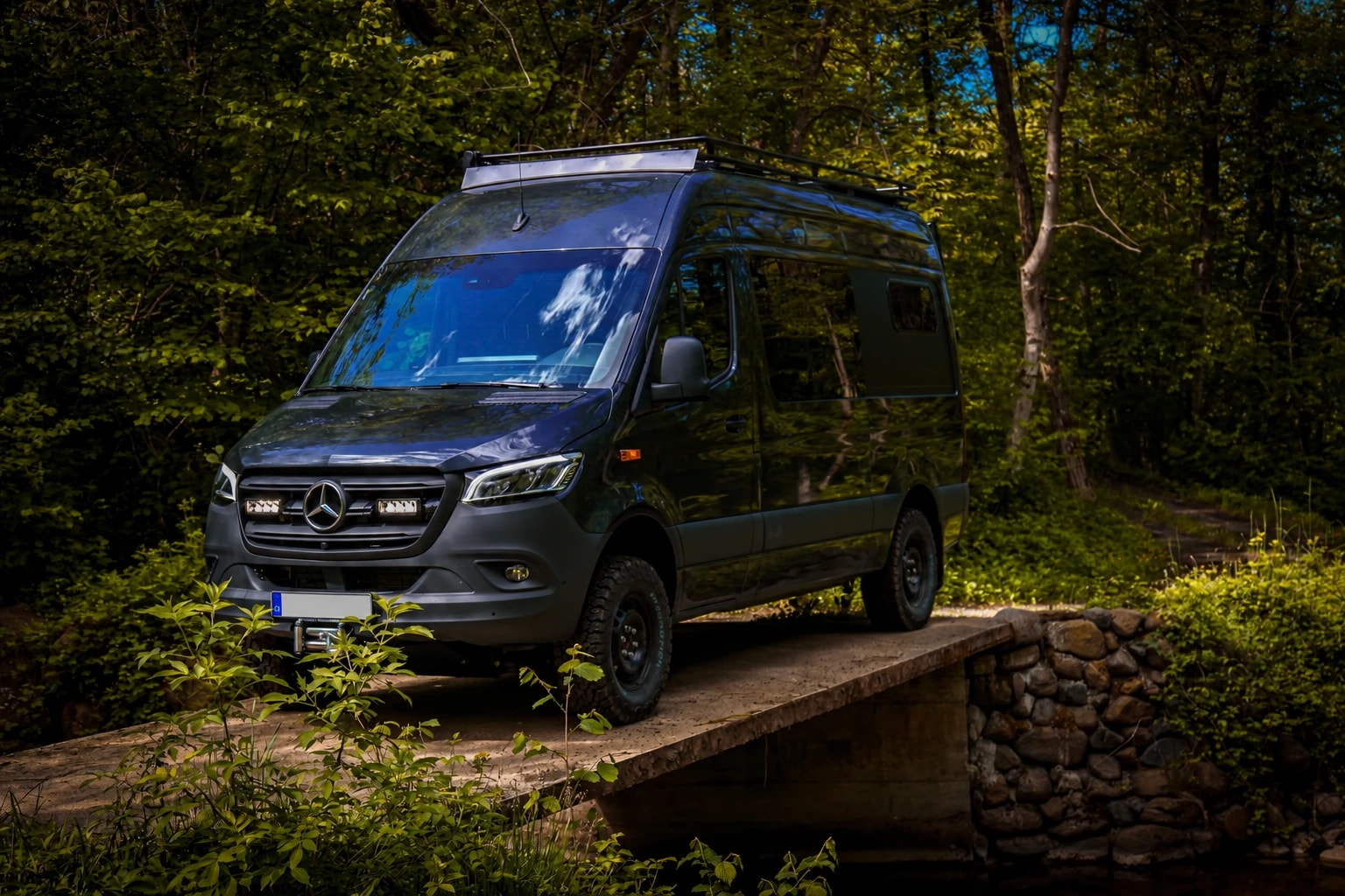 Mercedes-Benz Sprinter 4x4 von Busmacher auf einer Steinbrücke im Wald
