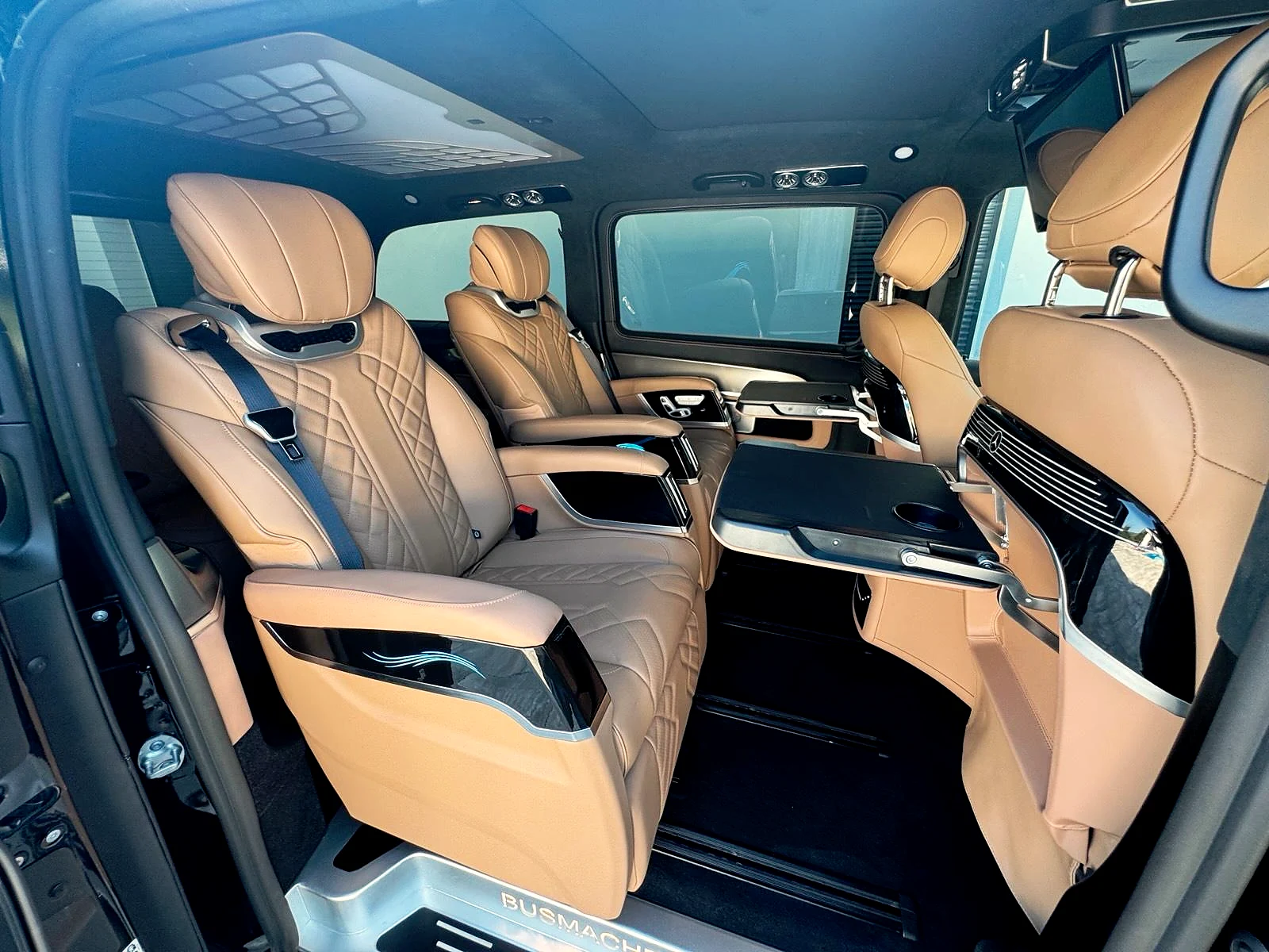 Ledereinzelsitze mit ausgeklappten Tischen im V-Klasse VIP-Ausbau von Busmacher