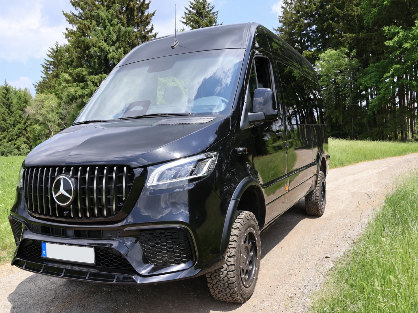 Schwarzer Mercedes-Benz Sprinter VIP-Bus von Busmacher auf einem Waldweg
