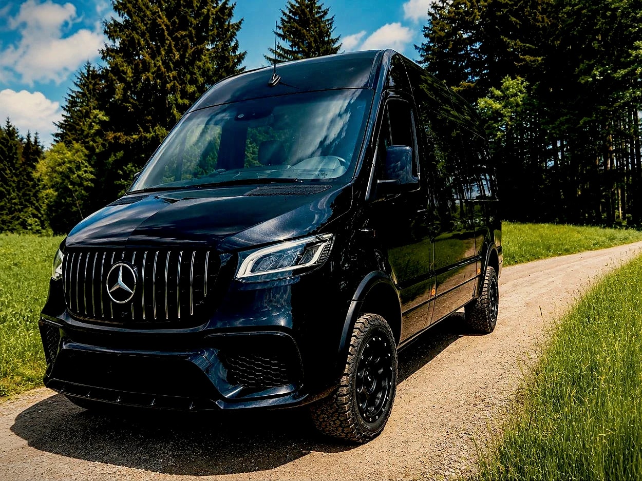 Schwarzer Mercedes-Benz Sprinter von Busmacher mit Allrad auf einem Waldweg
