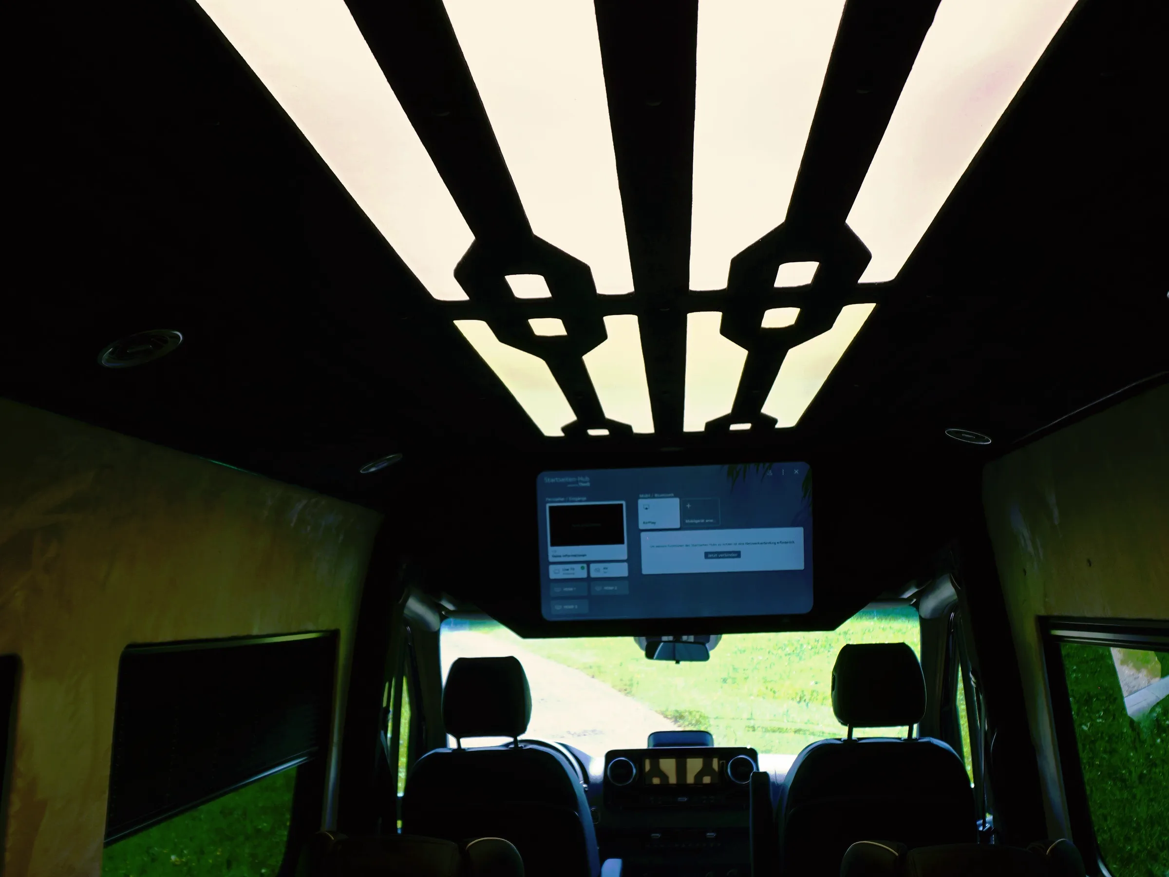 Beleuchtete Deckenpaneele im Fond eines Busmacher VIP-Busses bei Nacht